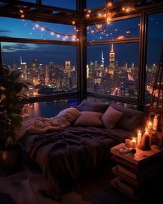 a bedroom with a large window overlooking the city lights and candles on the bed are lit up