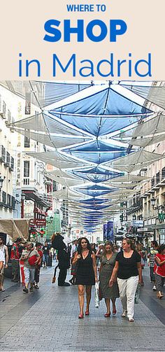 there are many people walking down the street with umbrellas over their heads in madrid, spain