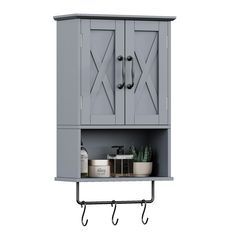 a gray cabinet with two hooks on the side and a potted plant next to it