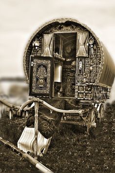 an old fashioned covered wagon sitting in the grass