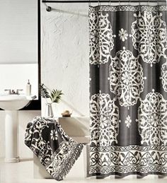 a black and white shower curtain with an intricate design in the middle is next to a sink