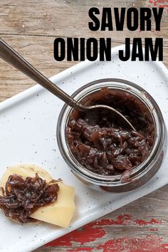 a jar of jam with a spoon next to it on a white plate and wooden table