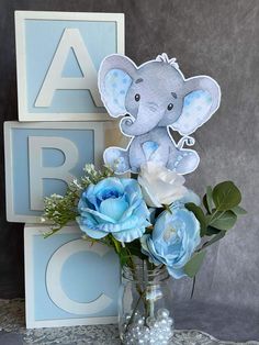 a vase filled with blue flowers and an elephant cutout