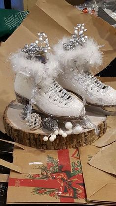 two pairs of white ice skates sitting on top of a piece of paper next to scissors