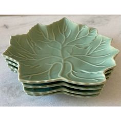 a set of four green dishes sitting on top of a table