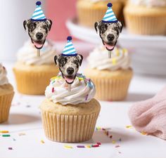 some cupcakes with pictures of dogs on them and sprinkles around them