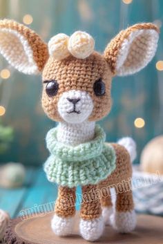 a small crocheted animal is standing on a tree stump with lights in the background