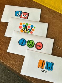 three pieces of paper with different logos on them sitting on top of a wooden table