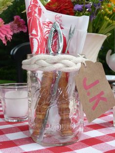 a glass jar filled with different types of items on top of a checkered table cloth