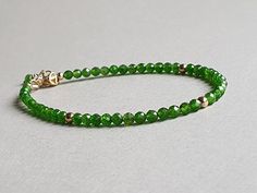 A lovely, vibrant green bracelet, made with chrome diopside rondelles and gold filled findings.  Available also in sterling silver option.  Please measure tightly your wrist's circumference, using a thread or something similar, and then measuring the thread with a ruler. When ordering, please select the actual wrist size, not the size of the bracelet.  I will make the bracelet fit your wrist, by adding approx 0.6 inch to the circumference. Diopside, also called ' The Analytical Stone' is an empowering stone that helps to stimulate learning and understanding, to help one become better connected to the earth, and to bring love to oneself as well as other. Said to hold all the mysteries of the Universe many find that the green Chrome Diopside as a direct connection with Gia or Mother Earth as Everyday Green Jewelry With Spacer Beads, Green Rondelle Bracelets With Faceted Beads, Diopside Jewelry, Solid Silver Bracelets, Green Bracelet, Black Onyx Bracelet, Tourmaline Bracelet, Aquamarine Jewelry, Onyx Bracelet