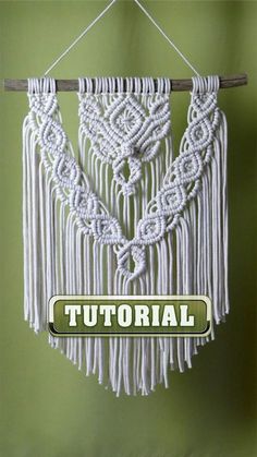 a white macrame hanging on a green wall