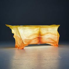 an unusual table made out of wood and glass is shown in the dark room with light coming from it