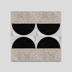 a black and white tile with three circles on the center, in front of a gray background