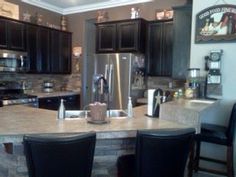 a kitchen with granite counter tops and black chairs