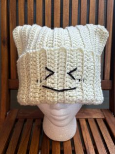 a white knitted hat on top of a wooden chair