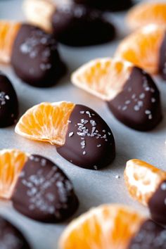 orange slices and chocolates are arranged on a baking sheet