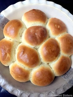 a white plate topped with rolls on top of a table