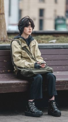 a woman sitting on top of a wooden bench