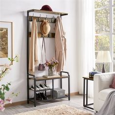 a coat rack with shoes and hats on it in a living room next to a couch