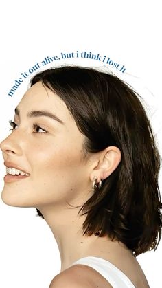 a woman with short hair and earrings on her head looking up to the side, in front of a white background