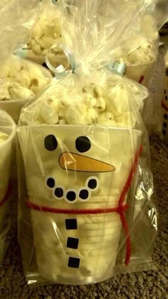 some cups with popcorn in them are decorated like a snowman