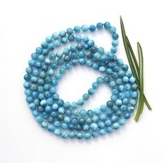 This vivid cyan colored piece of jewelry is made of blue Apatite. Overall length of the necklace is 115 cm; 45.3 inches.  The round smooth opaque beads are 6.5 mm in diameter. Weighs 78 grams. Beading thread is turquoise in colour. The beads on a string are separated by tiny hand tied knots preventing beads rubbing against each other, allowing the necklace drape better and adding an extra finished look. The necklace is without a clasp. You can slip it right over your head without having to worry about which part of the necklace is facing forward. Versatile uses: 1. Can be worn as a long necklace. 2. Can be worn double-wrapped around the neck as a layered jewelry. 3. The necklace wraps comfortably six times around the wrist to make an eye-catching stacked bracelet.  Beautiful on its own and Blue Apatite Jewelry, Apatite Jewelry, Apatite Necklace, Beading Thread, Wrap Necklace, Wrap Necklaces, Bracelet Blue, Tiny Hand, Blue Apatite