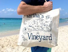 Oversized tote bag to carry whatever you need to your destination. This large bag, featuring Martha's Vineyard, Massachusetts, is great to have on hand for impromptu trips to the beach and weekend adventures. • Our largest tote bag is big enough for all your adventures: big and small. • Ideal gift bag for weddings, corporate events, and party favors. • Ideal gift bag for weddings, corporate events, and party favors. • 100% natural cotton (10 oz canvas). • Approximately 19″ x 15″ with a 5 gusset Large Travel Canvas Bag, Vacation Travel Tote Bag, Large Capacity Bags For Weekend Beach Trips, Travel Tote Bag For Vacation, Large Capacity Tote Beach Bag For Weekend Trips, Rectangular Beach Bag For Weekend Vacation Trips, Rectangular Beach Bag For Vacation Weekend Trips, Rectangular Beach Bag For Weekend Trips, Vacation Travel Tote Beach Bag