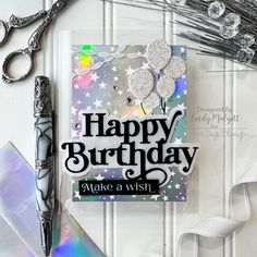 a happy birthday card with scissors, ribbon and other crafting supplies on a table