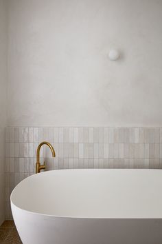 a white bath tub sitting next to a wall