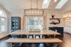 a dining room table with benches in front of it