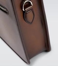 This Berluti briefcase is made in Italy from brown leather. It features two top handles and a detachable shoulder strap..Internal details: internal zipped pocket, fabric lining, internal slot pockets.Color of fastening: antique silver.Made in Italy.Designer color name: Cacao Intenso.Zipped front pocket.Closure: two-way zipped top.Detachable, adjustable shoulder strap, Top handles.Material: leather.Height 27cm-10.5'.Width 38cm-15'.Depth 6cm-2.5'.Length of handles 35cm-14'.Min. length shoulder str Berluti Bag, Travel Collection, Leather Briefcase, Strap Top, Embossed Logo, Color Names, Front Pocket, Top Handle, Antique Silver