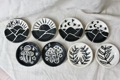 six black and white plates with designs on them sitting on a tablecloth covered surface