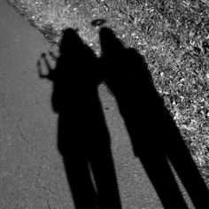 the shadow of two people standing next to each other