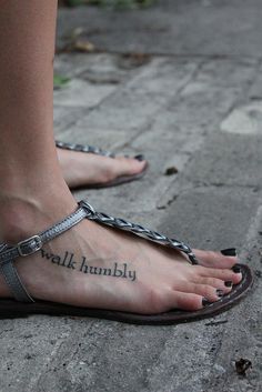 a woman's foot with a tattoo on it and the words walk humbly