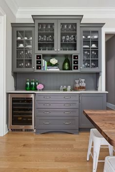 a kitchen with gray cabinets and wooden floors