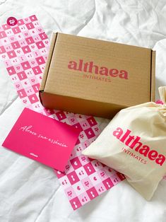 an open box and some pink items on a bed