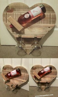 two wine glasses sitting on top of a wooden heart shaped shelf with bottles in it