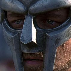 a close up of a man wearing a helmet and looking at the camera with an intense look on his face