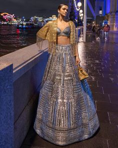 This lehenga set features antique silver sequin embroidery in a geometric pattern. The blouse shows crystal tassels at the waist. Embroidered dupatta also shows crystal tassels. The outfit can be paired with (an optional) antique gold cape jacket with matching embroidery. The jacket has heavy beaded tassels.From Seema Gujral's For the love of London collection. DELIVERY TIMEPlease allow 8-12 weeks for your outfit to arrive. FABRIC DETAILSNet Professional cleaning only. Sequin Lehenga, Jacket Lehenga, Tassel Embroidery, Cape Lehenga, Seema Gujral, Matching Embroidery, Tassel Jacket, Kurta Lehenga, Sequin Cape