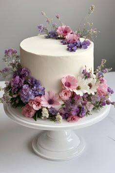 a white cake with pink and purple flowers on top