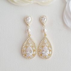 14K Gold Plated Cubic Zirconia Earrings for Weddings Add these gold cubic zirconia earrings to your wedding day ensemble for that extra dazzle. These elegant earrings will is great for brides with some big sparkle and a touch of gold. The earrings are 14K gold plated with cubic zirconia drop and a pearl centered. The earrings are lightweight and comfortable and measure 1 7/8 inches or 4.9 cms. You could combine the Esther range of earrings, necklaces all in 14K gold plating to complement each ot Gold Pearl Wedding Earrings, Gold Dangle Earrings Wedding, Expensive Earrings, Gold Wedding Earrings, Rose Gold Bridal Earrings, Gold Earrings Wedding, Bridal Earrings Drop, Gold Bridal Earrings, Wedding Earrings Drop