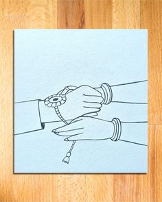 two hands holding each other on top of a piece of paper