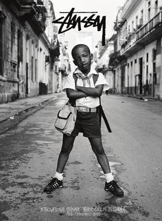 a young boy is standing in the middle of an empty street with his arms crossed