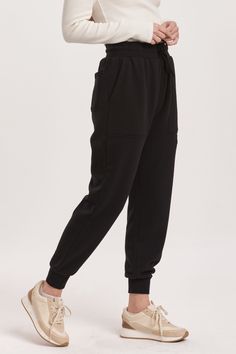 High rise ankle jogger pants with drawstring option to wear tightly or loosely for a comfy wear with utility front & back pouch pockets. Perfect for any comfy time, when you just want to cozy up! Solid color knit on relaxed fit.14" Front Rise (include waistband), 9 1/2" Leg Opening, 28" inseam (Size Small) 100% COTTON Machine wash cold, Tumble dry low Imported Black Joggers With Tapered Leg And Pockets, Black Tapered Leg Joggers With Pockets, Sporty Ankle-length Joggers With Drawstring, Sporty Drawstring Ankle-length Joggers, Black Relaxed Fit Joggers With Cargo Pockets, Black Relaxed Fit Cargo Joggers, Sporty Cargo Pants With Elastic Waistband For Loungewear, Black Sweatpants With Drawstring For Sports, Black Drawstring Sweatpants For Sports