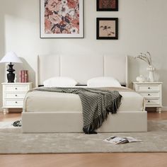 a bedroom with white furniture and pictures on the wall