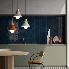 three lights hanging over a kitchen counter next to a dining room table with chairs around it