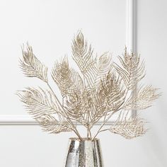 a silver vase with some plants in it