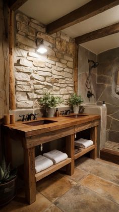 a rustic bathroom with stone walls and flooring, two sinks under the vanity area