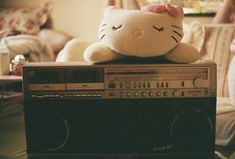 a hello kitty stuffed animal sitting on top of an old radio