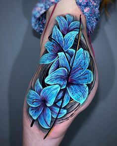 a woman's leg with blue flowers painted on the thigh and one flower in the middle